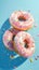 Whimsical delight pink donuts with colorful sprinkles on blue background