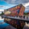 Whimsical depiction of Oslo& x27;s Viking Ship Museum with vibrant rainbow-colored fjord