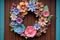 whimsical paper flower wreath on a rustic wooden door