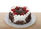 Whip cream frosted cake with chocolate chips and strawberries