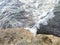 The whip lines of the ocean waves impact the rocks on the beach.