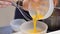 Whipped egg yolks with sugar in a glass bowl. Beaten egg yolks in a bowl with whisk. Beaten egg yolk