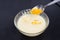 Whipped eggs in glass bowl with and citrus peel on kitchen