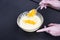 Whipped eggs in glass bowl with and citrus peel in woman hands