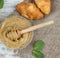 Whipped honey with apricot on a table in a jar with a spoon spindle, next to croissants and mint, top view