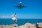 Whirlpool of Wonder: Girl in White Dress, Stones, Blue Sea, and an Airborne Plane