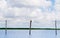 Whiskered Tern birds on wood poles against summer sky and landscape of Talay Noi, Ramsar wetland resevoir of Songkhla lake