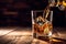 Whiskey being poured into a glass with ice.