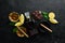 Whiskey, chocolate and cigars on a black stone table. Top view.