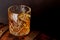 Whiskey glass with ice on a rustic barrel, a classic sip