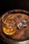 Whiskey glass with ice on a rustic barrel, a classic sip