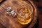 Whiskey glass with ice on a rustic barrel, a classic sip