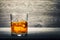 Whiskey glass and ice on wooden background