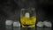 Whiskey with ice. Adding ice cubes on black background. Glass of rum alcohol