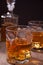 Whiskey with ice on a wooden table. Nearby bottle