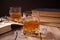 Whiskey with ice on a wooden table. Nearby old books