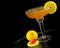 A whisky sour in a coupe glass with a lemon wagon wheel garnish on a round table with dark background. Perspective is tilted.