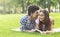 Whispering about love. Romantic teenagers laying on grass outdoors