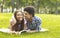 Whispering about love. Romantic teenagers laying on grass outdoors