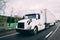 White 18 wheeler semi-truck on highway with motion blur