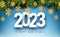 White 2023sign with hanging yellow paper snowflakes