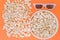 White 3d glasses paper cup and fresh cheesy popcorn on a orange background, top view, copyspace