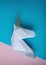 White 3d papercraft model of unicorn head on bright background. Minimal art concept