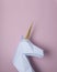 White 3d papercraft model of unicorn head on pink background. Minimal art concept