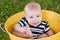 White 7-month-old baby in yellow bucket