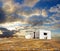 White abandoned house under dramatic sunset skies