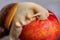 White Achatina snail on the table next to a juicy fresh peach. Close-up photo of exotic pets.