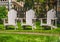 White Adirondack chair setting at the garden. Traditional curveback red wooden beach chair. Red Muskoka chairs in a park