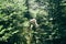 White adorable dog playing in forest on sunny day