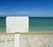 White advice panel on a beach with ocean on the background. for graphical concept