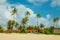 white African houses of European style with a tiled roof on the sand under palm tree