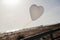 White Air Balloons heart shaped flying in blue sky. Love concept. Holiday celebration
