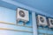 White air conditioners on the blue wall of the house. Modern climate control technologies