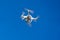White air drone quadrocopter against the blue sky