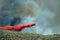 White Aircraft Dropping Fire Retardant as it Battles the Raging Wildfire