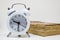 White alarm clock and Old book (Dictionary) on white background