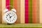 White alarm clock is over multicolor bamboo mat background
