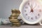 White alarmclock with Coins stack and stack of one hundred dollar bills on grey background.Interest rate and dividend concept,