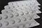 White aluminium blister pill pharmacy medicine health care template concept. White drug on isolated black wooden board