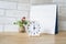 White analog clock with blurred calendar on wooden desk