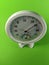 White analog hygrometer on green background