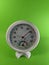 White analog hygrometer on green background