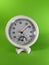 White analog hygrometer on green background