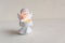 White angel candleholder with lighted candle on white