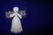 White angel with wings on blue background with copy space. Prayed thread doll as a symbol of love, charity and faith. Christmas