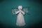 White angel with wings on cyan background. Prayed thread doll as a symbol of love, charity and faith. Christmas and New Year